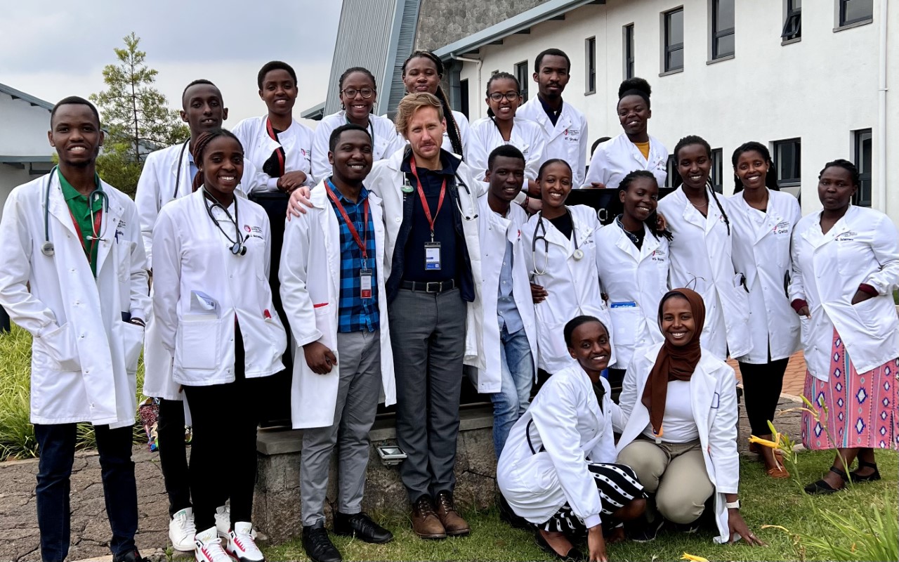 Dr. Andrew Enslen, a global health track resident at the time, spent six weeks in the spring of 2023 working with UGHE in a local district hospital, functioning as a consultant attending physician who supervised and taught 3rd-year medical students (pictured here). Working closely with these passionate and committed students was a highlight of his experience, he said. 